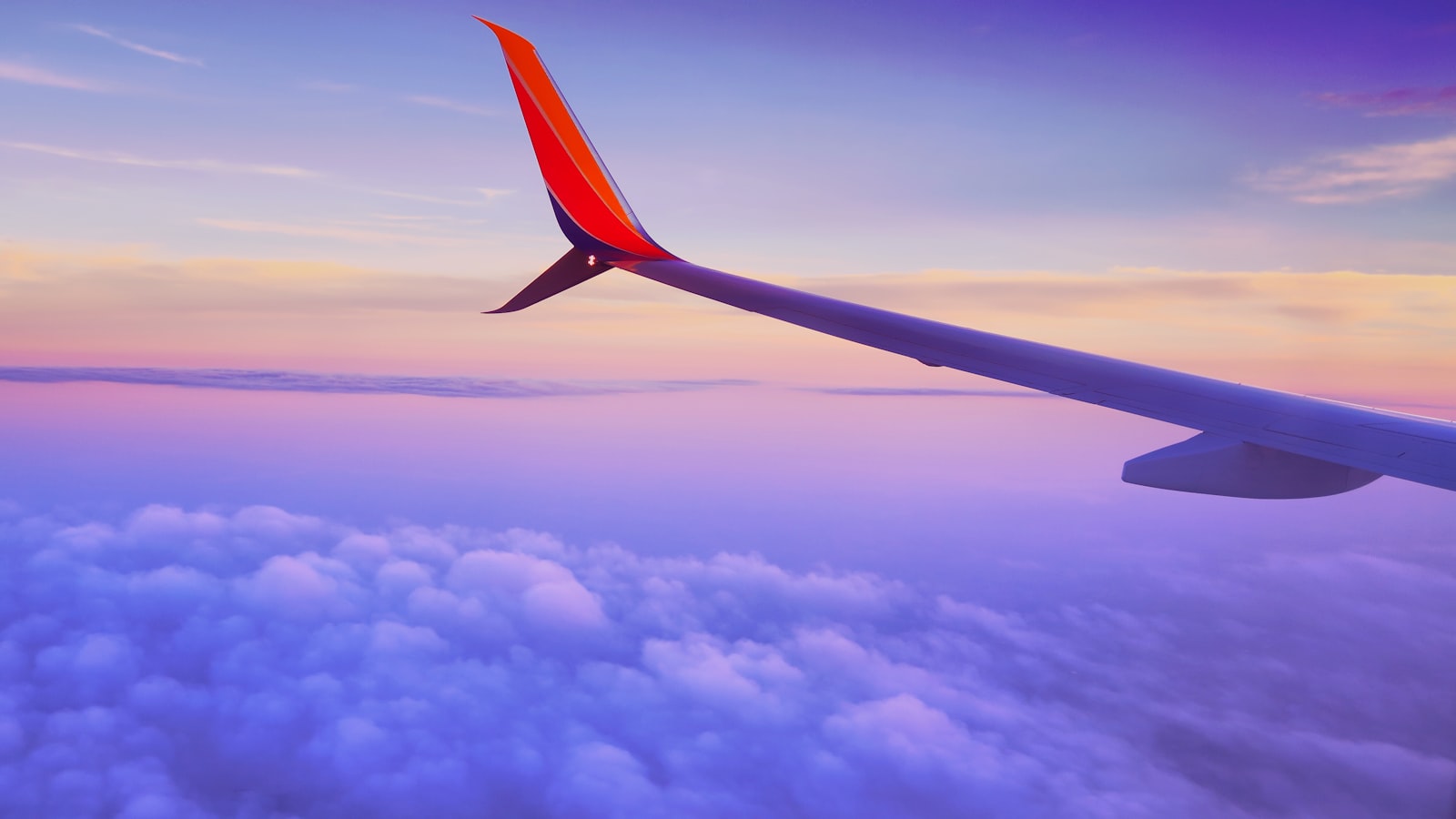 A lone traveller looking out over a vast dramatic landscape on a long-dreamed-of journey